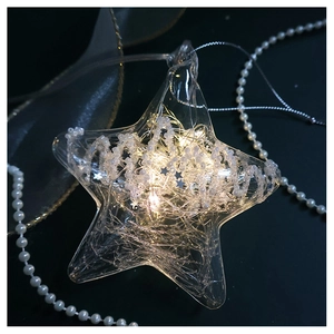 Detailed macro of a warm white LED star ornament with clear glass and interior pearls