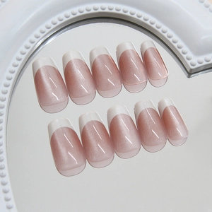 Pink cat eye French press-on nails with white tips on decorative mirror base