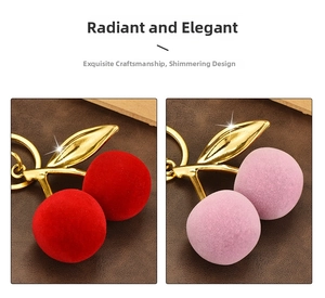 Detail of red and pink flocked cherry keychains with golden metal leaves and stems