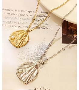 Detailed macro view of gold and silver shell pendants with pearls on cross chains