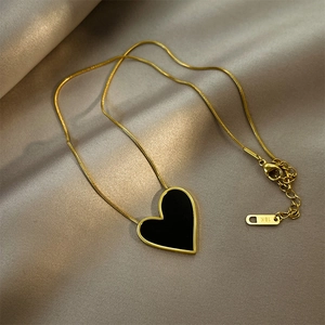 Elegant 18k gold plated titanium necklace with large black heart pendant on silk cloth