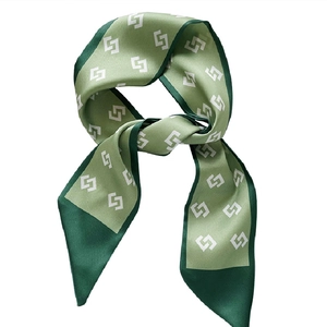 Green silk skinny scarf with geometric white patterns and dark green borders on white background