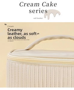 Close-up of soft cream leather makeup bag with vertical quilting and top handle detail