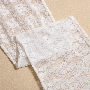 Close-up of white floral lace fabric showing fine embroidery and intricate hollow pattern