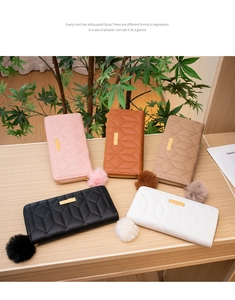 Detail view of colorful PU leather long wallets with quilted pattern and fluffy pompoms