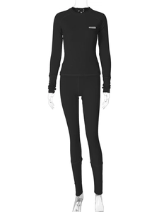 Détail du tissu côtelé noir sur l'ensemble haut à manches longues et pantalon ajusté