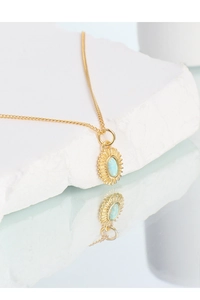 Detailed view of S925 silver gold-plated sunburst pendant with light blue opal stone