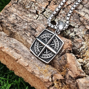 Close-up of vintage compass square pendant on tree bark with antique silver finish