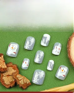 Detail of Christmas press-on nails with grey glitter, white snowmen and snowflake art