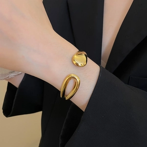 Polished 18k gold plated stainless steel teardrop cuff bracelet on a model wrist