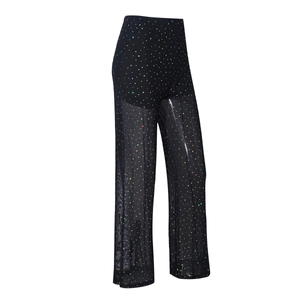Detail of sheer black mesh flared trousers featuring shimmering colorful rhinestones