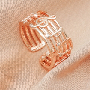 Rose gold adjustable music ring with treble clef and sparkling crystals on silk
