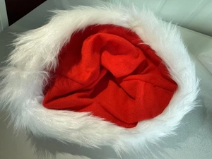 Close-up of red knitted Christmas hat featuring a thick white faux fur plush border