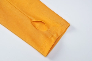Gros plan sur la manche en tricot jaune avec passage de pouce et finitions de couture
