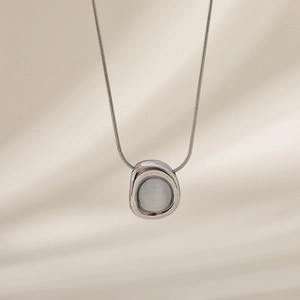 Detailed close-up of a silver stainless steel snake chain with a white opal pendant