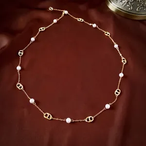 Elegant gold plated necklace with pearls and coffee bean links on red silk background