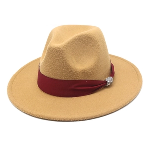 Detail of camel wool fedora hat with red ribbon band and rhinestone buckle accent