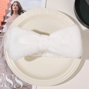 Close-up of a white plush bow headband on a vintage porcelain plate with soft texture