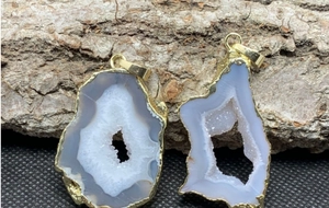 Dettaglio del ciondolo in geode di agata naturale con bordo placcato oro 14K su corteccia