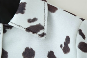 Détail de la veste à imprimé vache montrant le col et la texture du tissu épais