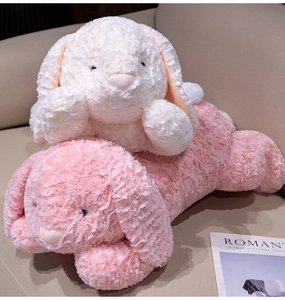 Detail van zachte pluche konijnen in roze en wit met rozenkrul-textuur op een bank
