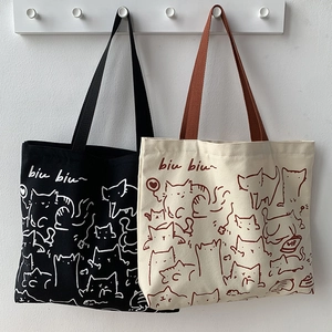 Detail of artistic cat illustration prints on black and beige canvas tote bags