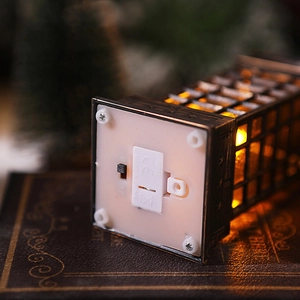 Macro detail of Christmas lantern base showing the battery compartment and power switch