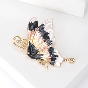 Detailed view of enamel butterfly brooch with rhinestones on a clean white pedestal