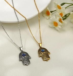 Detail of Hamsa Hand and Evil Eye pendants with protection strength engraving