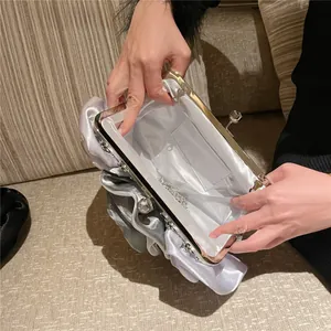 Interior view of silver satin evening clutch showing metal chain and white lining
