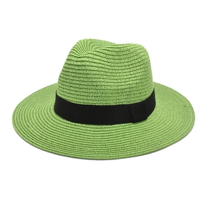 Detail of lime green woven straw Panama hat with black ribbon band on white background
