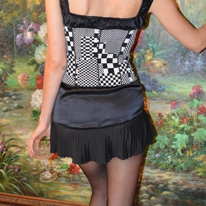 Women's back view of a checkered strap top and black pleated skirt in a vintage style