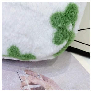 Detailed close-up of soft plush faux fur fabric with green spots and fuzzy texture