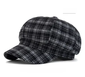 Detailed close-up of a black and grey plaid newsboy cap with classic textured wool fabric