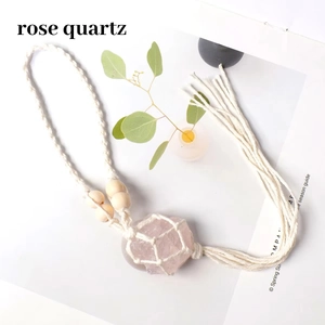 Detail of bohemian hand-woven cotton net pouch with rose quartz and wood beads