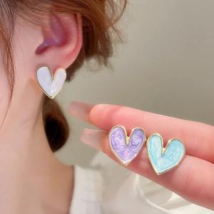 Detailed macro view of colorful enamel heart studs with golden edges and pearl texture