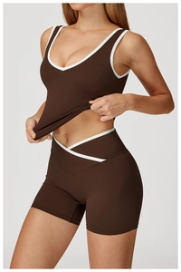 Detail of cross V-waist yoga shorts and racerback tank top with white piping accents