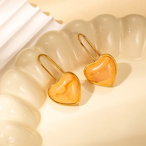 Sweet orange marble resin heart earrings with gold hooks on a cream tray