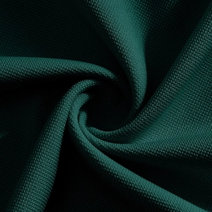 Detailed macro view of dark green moisture-wicking fabric with fine knitted texture