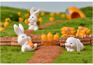 Close-up details of cute resin rabbit and carrot miniatures for micro landscape decor.