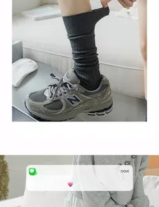 Detail of dark grey ribbed knit knee high socks styled with athletic sneakers