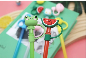 Close-up detail of cute cartoon silicone straw cap with frog and watermelon design for drinks.