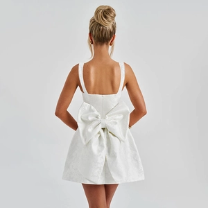 Gros plan d'une robe mini en jacquard blanc avec un grand nœud décoratif élégant dans le dos