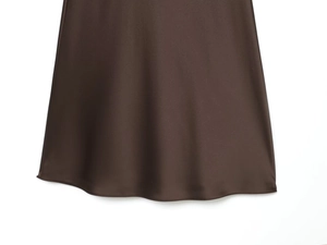 Detailed macro view of the dark brown satin dress hem with fine stitching and silky texture