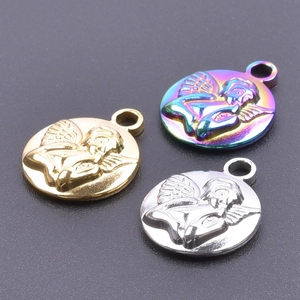Three stainless steel angel charms in gold, silver, and rainbow colors on a grey surface