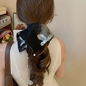 Détail d'un serre-tête en tissu à motifs d'encre avec d'élégantes perles sur un mannequin