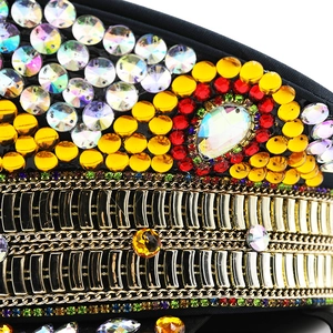 Macro detail of disco captain hat featuring golden chains and colorful rhinestones