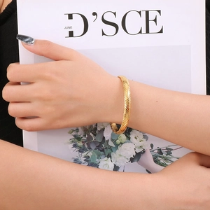 French vintage style C-shaped golden titanium steel cuff bracelet worn by a model