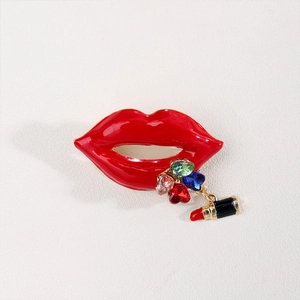 Macro shot of red lip brooch with dangling colorful rhinestones and mini lipstick charm