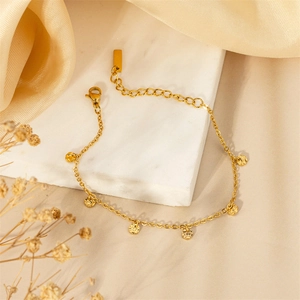 Elegante bracciale in titanio placcato oro 18K con dischi martellati su base marmo